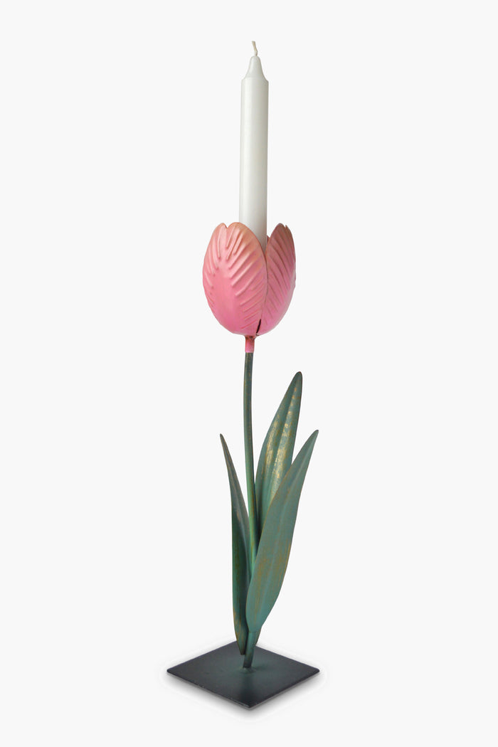 The Chefanie Tulip Candle Holder, shaped like a pink flower with green leaves and stem on a square black base, holds a white taper candle—an elegant colored metal candlestick perfect for springtime tablescapes.