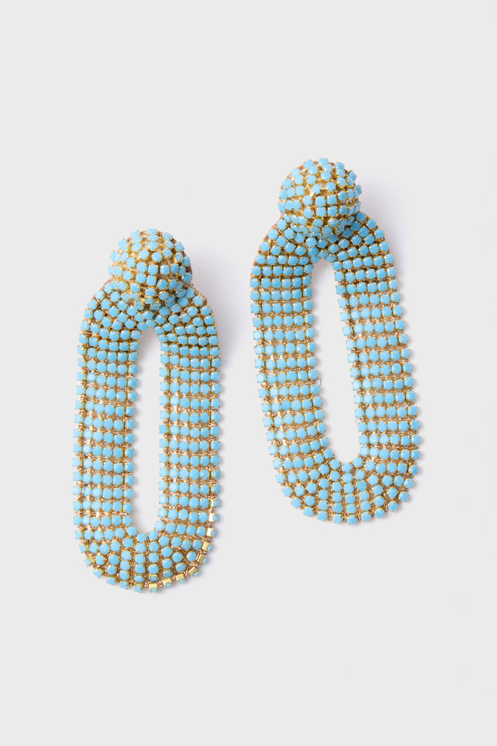 The Deepa Gurnani Turquoise Bianca Earrings are handcrafted dangle earrings with elongated ovals, adorned with blue and gold beads and inspired by Indian hand embroidery.