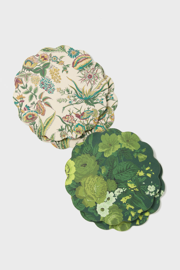 Two scalloped-edged coasters by Tuckernuck Home, made of polyurethane leather with colorful floral designs, are stacked on a white surface. These reversible coasters add both style and practicality to your table setting.