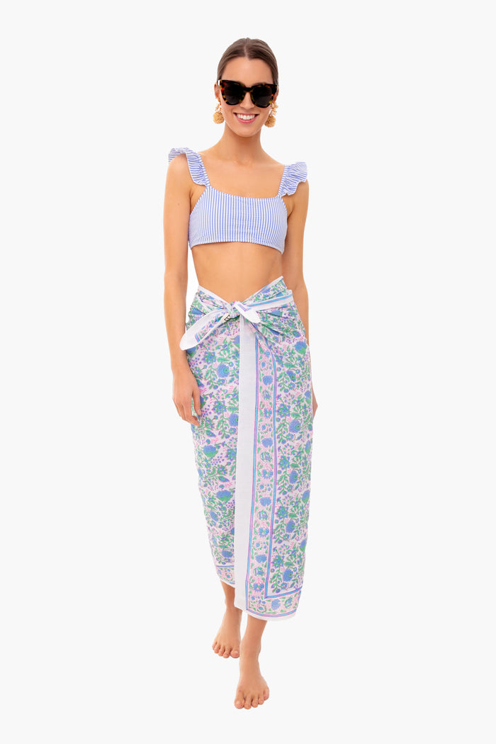A woman stands barefoot in SZ Blockprints sunglasses, a blue-striped crop top, and a floral Indian cotton sarong—a relaxed style captured in this hand block printed cotton beach coverup.