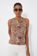 A person stands confidently wearing sunglasses, gold jewelry, white pants, and a Ulla Johnson stretch jersey tank with paisley print.