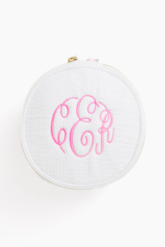 Caton's Wharf round white zippered button bag with a textured surface and pink monogram initials embroidered on top.