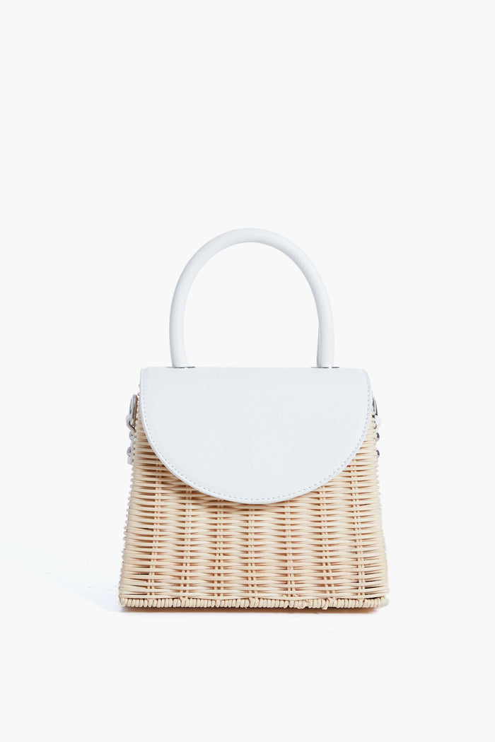 The Olga Berg small structured wicker top handle bag features a white vegan leather flap closure and matching handle, making it perfect for evening bag collections.