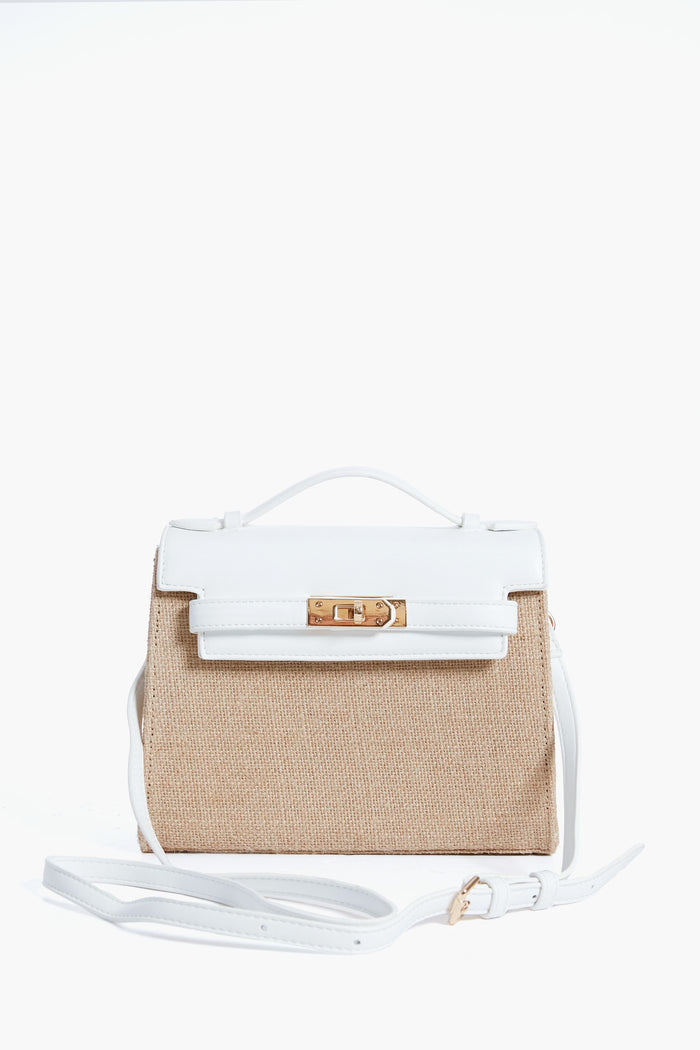 A structured Urban Expressions bag with a beige woven body, white vegan leather flap and handle, gold-tone clasp, and adjustable white shoulder strap.