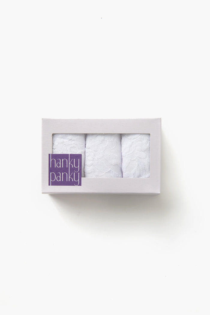 A white box labeled "Hanky Panky" in purple, with a clear window, displays three folded white lace low-rise thong lingerie pieces designed for a no visible panty line look.