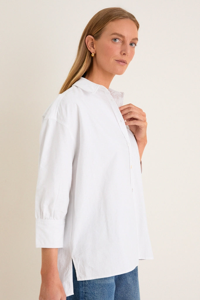 Woman wearing the classic White Oxford Adair Boyfriend Shirt with rolled sleeves, exuding an effortless, high-end style that's perfect for fun, versatile pairings.