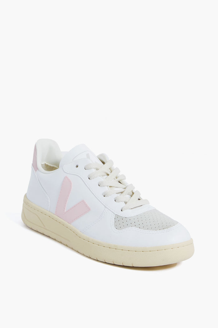 A VEJA white sneaker with an off-white sole, beige toe detail, and a light pink V logo on the side, crafted from recycled materials and displayed at a three-quarter angle.