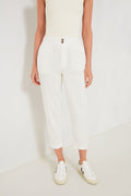 A person wears a Marine Layer sleeveless white top, ultra-soft white trousers with an elastic waistband and buttons, and white sneakers for a fresh, casual look.