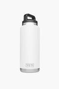 A white YETI Rambler Bottle with a black screw-on lid and handle stands upright. This stainless steel water bottle features vacuum insulation to keep beverages hot or cold for hours.