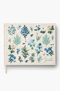 The Rifle Paper Co. beige hardcover guest book, titled "Guests," features green lettering and blue, green, and white floral embroidery—making it a charming keepsake for special occasions.