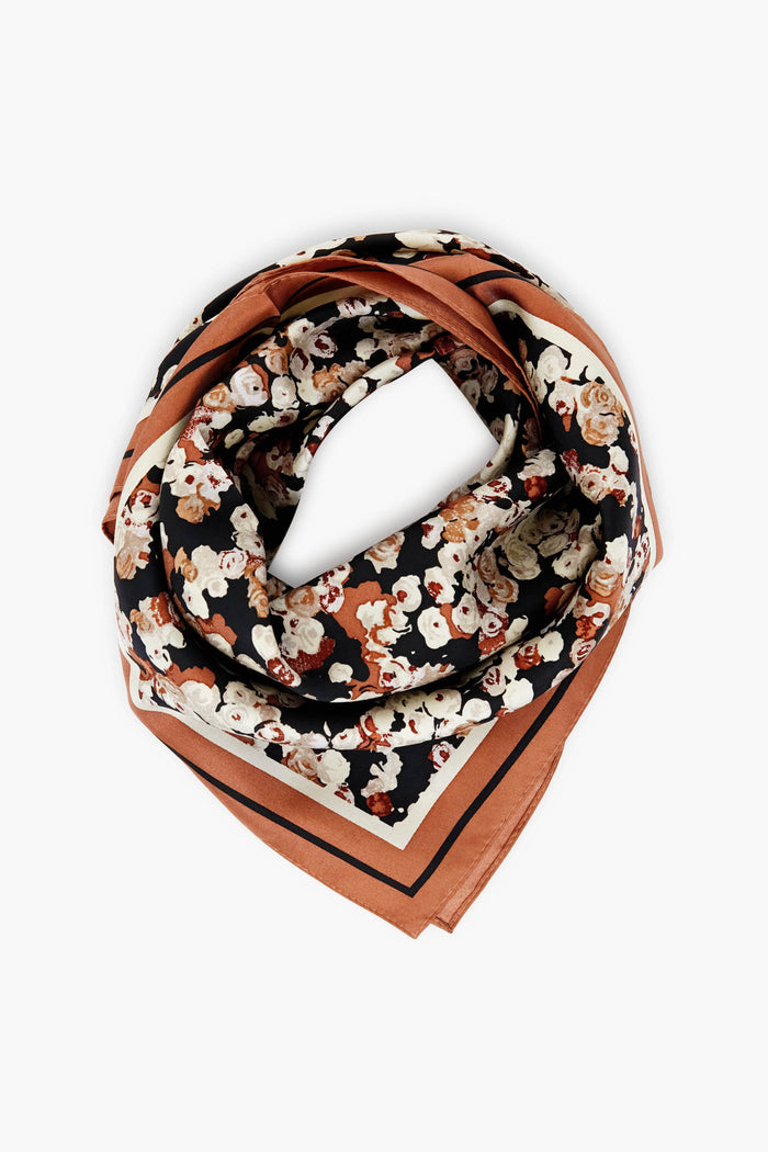 Tuckernuck Accessories square scarf features a floral pattern in black, brown, and cream tones, crafted from 100% silk and neatly folded.