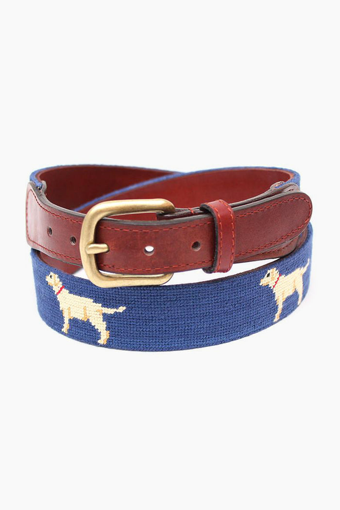 The Smathers and Branson blue needlepoint belt features brown leather trim, a brass buckle, and hand-stitched yellow dog motifs—an ideal gift for dog lovers.
