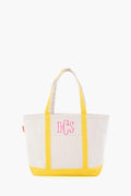 The CB Station beige canvas tote bag features yellow handles and trim, plus pink DCS monogram initials on the front. This stylish, reusable bag is ideal for everyday use.